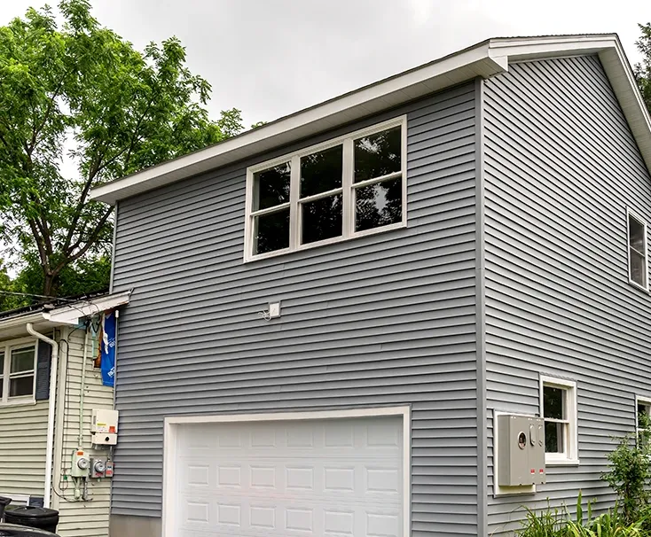 Exterior view of a charming New England home with a seamless structural addition built by Akaza Builders, a home addition contractor in Central MA.